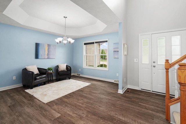 416 Rimrock Rd, Janesville, WI 53548 - entryway featuring dark wood-style floors, a tray ceiling, baseboards, a chandelier, and stairs