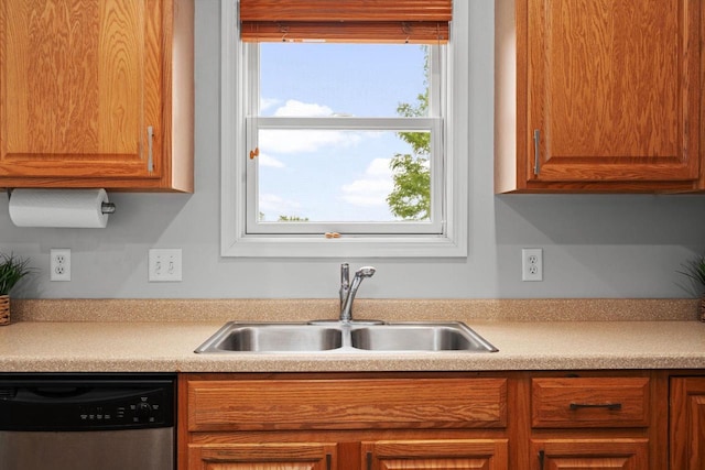 416 Rimrock Rd, Janesville, WI 53548 - kitchen featuring dishwasher, a sink, light countertops, and brown cabinetry