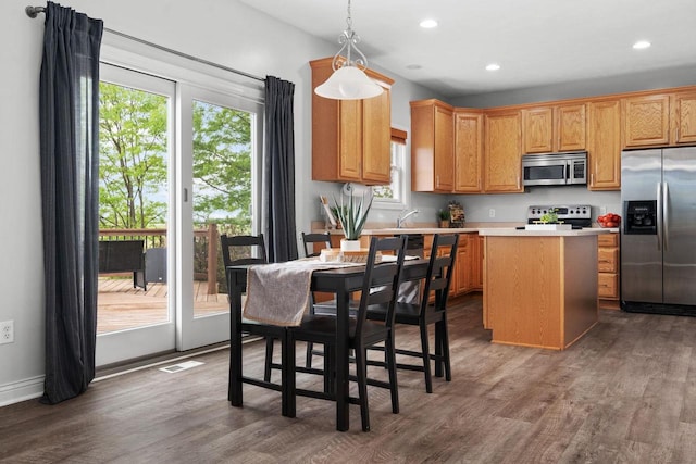 416 Rimrock Rd, Janesville, WI 53548 - kitchen featuring appliances with stainless steel finishes, wood finished floors, a center island, light countertops, and recessed lighting