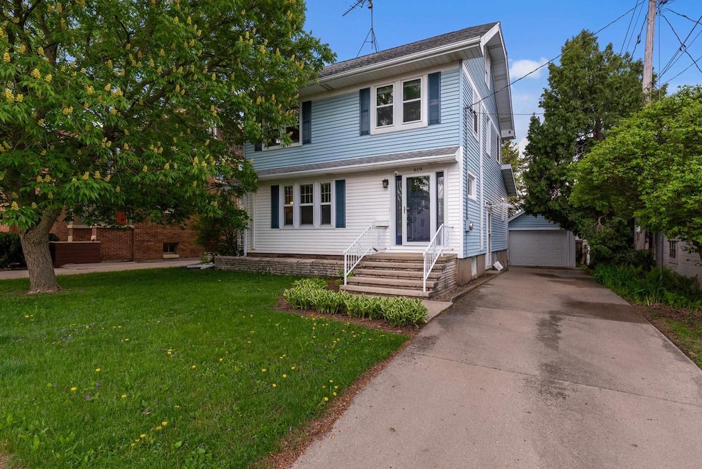 619 W Maple Ave, Beaver Dam, WI 53916 - view of front of house with a front yard, an outdoor structure, and a detached garage
