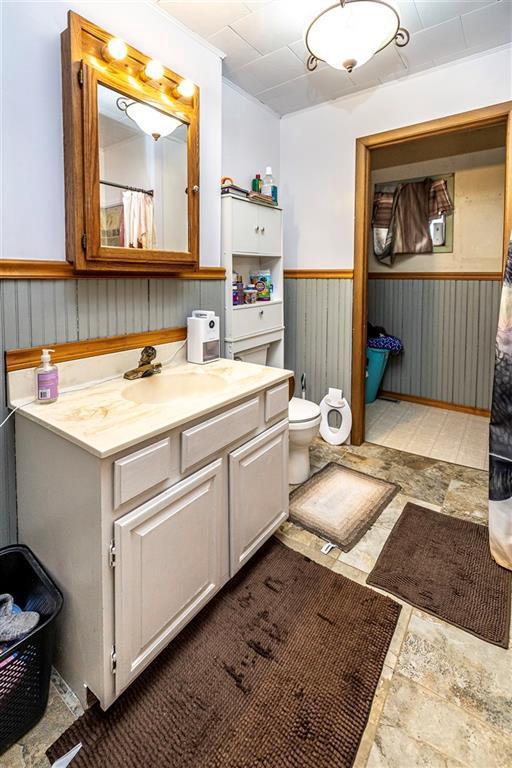 N9003 County Road Vv, Mindoro, WI 54644 - full bath featuring a wainscoted wall, vanity, and toilet
