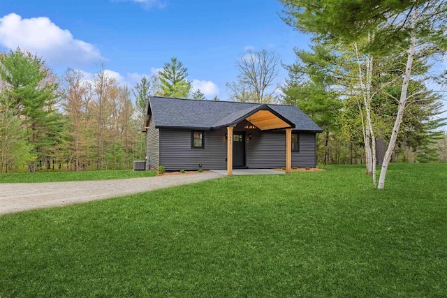 401 George St, Crivitz, WI 54114 - view of front of home with a shingled roof, a front yard, dirt driveway, and cooling unit