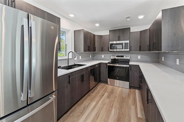 401 George St, Crivitz, WI 54114 - kitchen featuring appliances with stainless steel finishes, a sink, light wood-style floors, dark brown cabinets, and recessed lighting