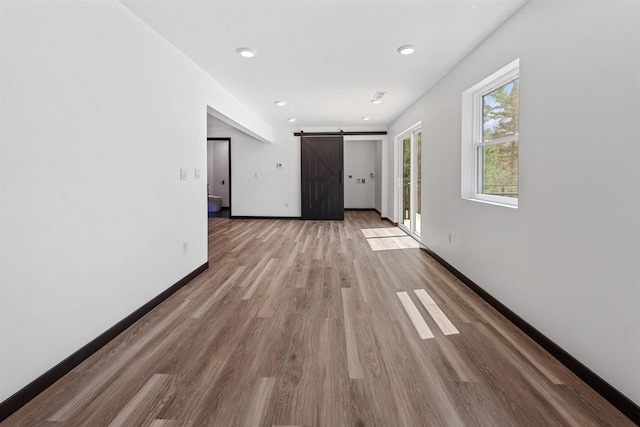 401 George St, Crivitz, WI 54114 - spare room featuring a barn door, wood finished floors, baseboards, and recessed lighting
