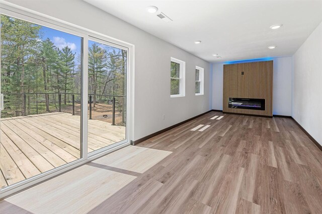401 George St, Crivitz, WI 54114 - unfurnished living room featuring a glass covered fireplace, wood finished floors, baseboards, and recessed lighting