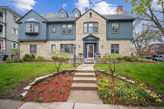 2017 N Terrace Ave, Milwaukee, WI 53202 - view of property featuring stone siding, a front yard, and a chimney