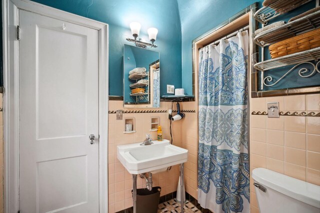 2017 N Terrace Ave, Milwaukee, WI 53202 - bathroom featuring tile walls, toilet, a shower with curtain, and a wainscoted wall