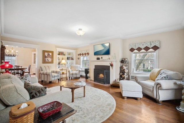 2017 N Terrace Ave, Milwaukee, WI 53202 - living room featuring a chandelier, a fireplace with flush hearth, ornamental molding, and wood finished floors