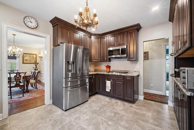 2017 N Terrace Ave, Milwaukee, WI 53202 - kitchen featuring appliances with stainless steel finishes, a chandelier, dark brown cabinetry, light stone counters, and baseboards