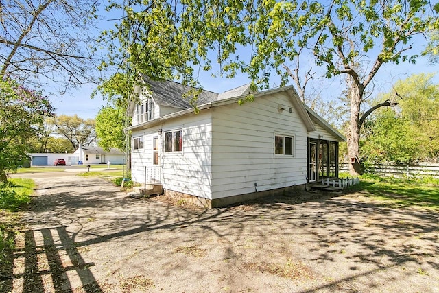412 W Chestnut St, Pardeeville, WI 53954 - view of side of property featuring entry steps, fence, a shingled roof, and a sunroom