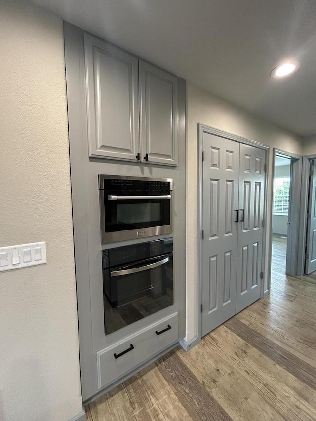 1341 S Wilson Ave Unit 10-4, Hartford, WI 53027 - kitchen with oven, light wood-style flooring, gray cabinetry, recessed lighting, and baseboards