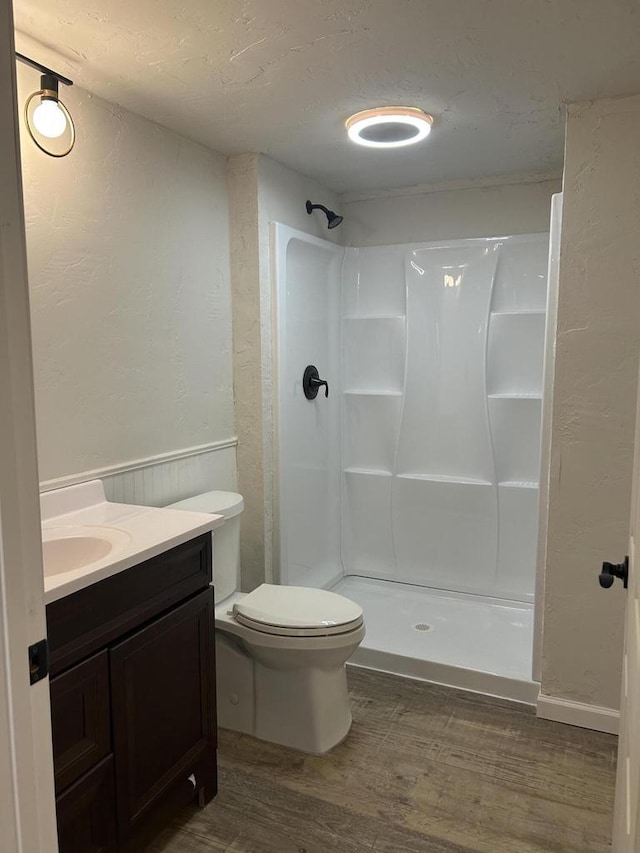 1341 S Wilson Ave Unit 10-4, Hartford, WI 53027 - bathroom featuring wood finished floors, a shower stall, vanity, toilet, and a textured wall
