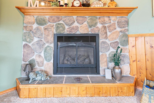 detailed view of a fireplace, carpet, and baseboards