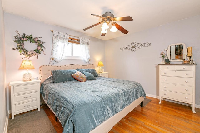 bedroom with baseboards, wood finished floors, and ceiling fan