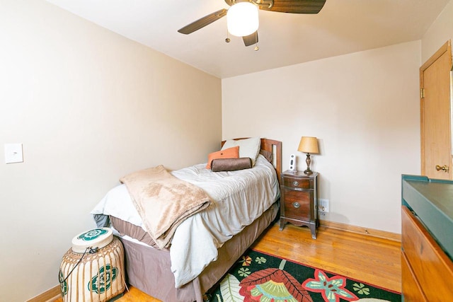 bedroom featuring wood finished floors, baseboards, and ceiling fan