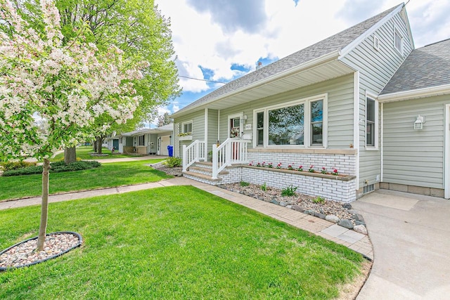 view of front of house with a front yard and a shingled roof