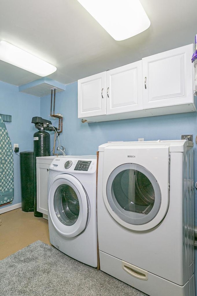 clothes washing area with cabinet space and washing machine and clothes dryer