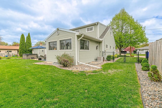back of house featuring a hot tub, a gate, and central air condition unit