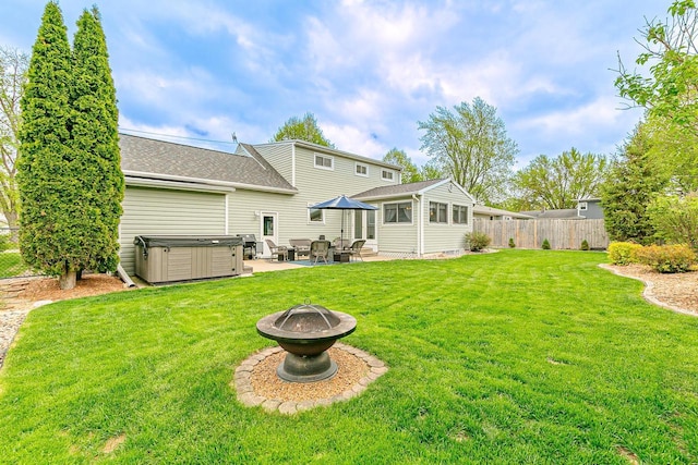 back of house featuring a hot tub, a patio area, a fire pit, and roof with shingles