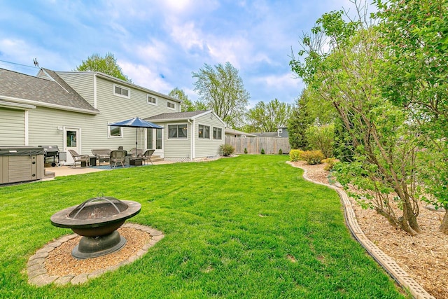 view of yard with a hot tub, a patio, and a fire pit
