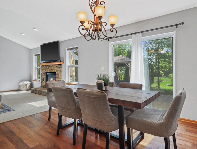 1537 Whitewater Dr, West Bend, WI 53095 - dining space with wood-type flooring, a chandelier, a fireplace, and baseboards