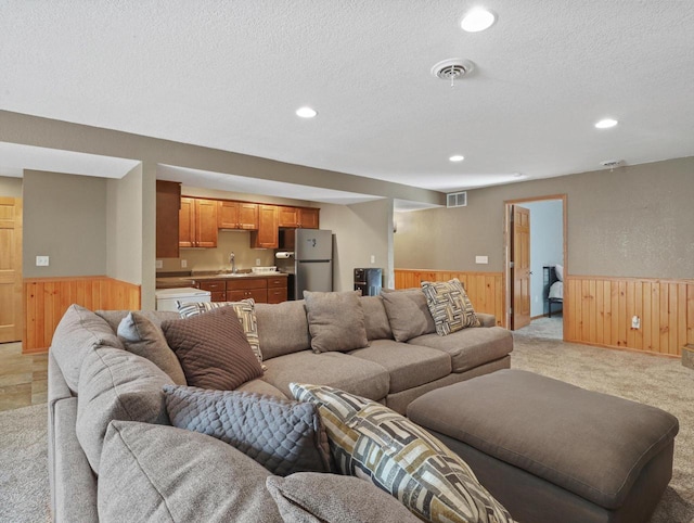 1537 Whitewater Dr, West Bend, WI 53095 - living room with a wainscoted wall, wood walls, recessed lighting, light carpet, and a textured ceiling