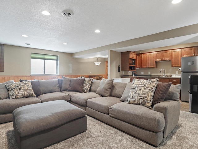 1537 Whitewater Dr, West Bend, WI 53095 - living room featuring wainscoting, recessed lighting, wooden walls, a textured ceiling, and light colored carpet