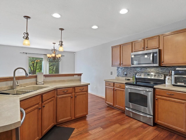 1537 Whitewater Dr, West Bend, WI 53095 - kitchen with stainless steel appliances, a sink, decorative backsplash, light countertops, and recessed lighting