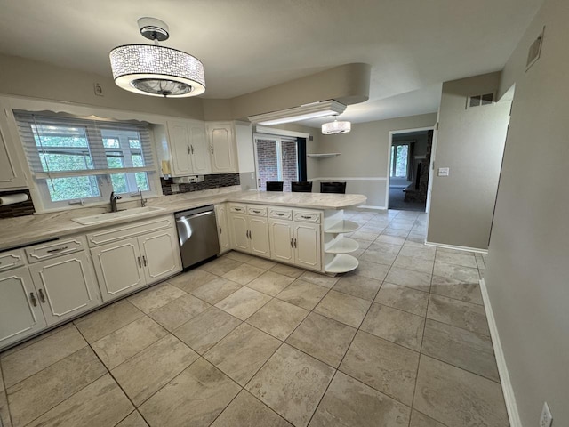 kitchen with dishwasher, a sink, white cabinets, light countertops, and a peninsula