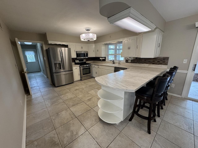 kitchen featuring stainless steel appliances, a peninsula, open shelves, and white cabinets