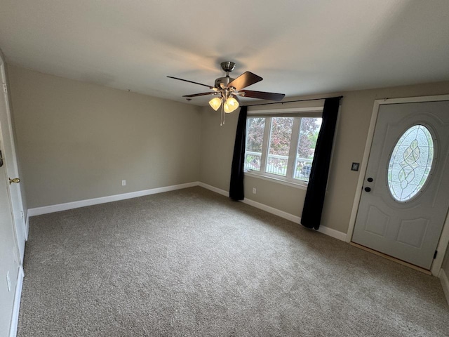 entrance foyer featuring ceiling fan, carpet flooring, and baseboards