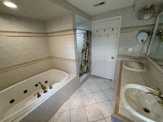 bathroom featuring tile walls, tile patterned floors, a whirlpool tub, double vanity, and a shower with shower curtain