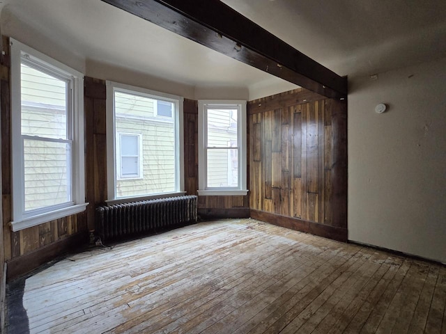 902 S 25th St, Milwaukee, WI 53204 - unfurnished room with radiator, hardwood / wood-style floors, wood walls, baseboards, and beam ceiling