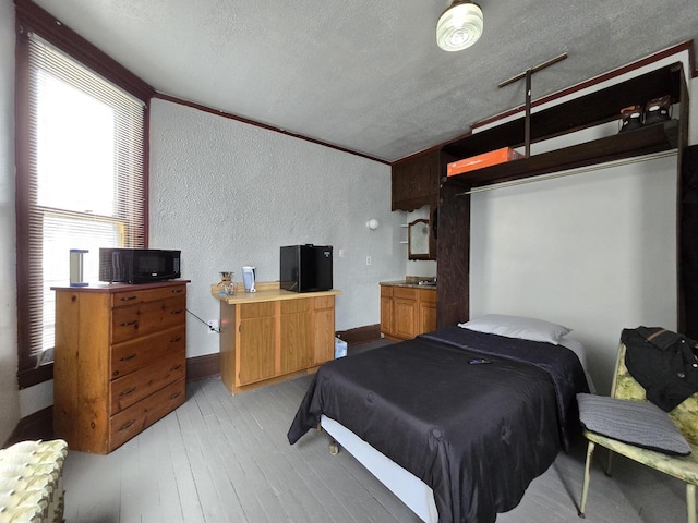 837 S 19th St, Milwaukee, WI 53204 - bedroom with a textured wall, a textured ceiling, light wood-style flooring, and baseboards