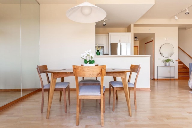 360 W Washington Ave Unit 1412, Madison, WI 53703 - dining area with rail lighting, light wood-type flooring, stairway, and baseboards