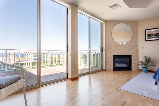 360 W Washington Ave Unit 1412, Madison, WI 53703 - living area with wood finished floors, a tiled fireplace, and a wall of windows