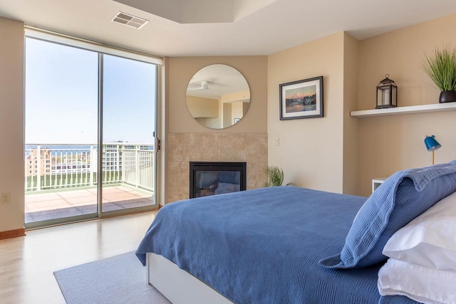 360 W Washington Ave Unit 1412, Madison, WI 53703 - bedroom featuring access to exterior, wood finished floors, and a tiled fireplace