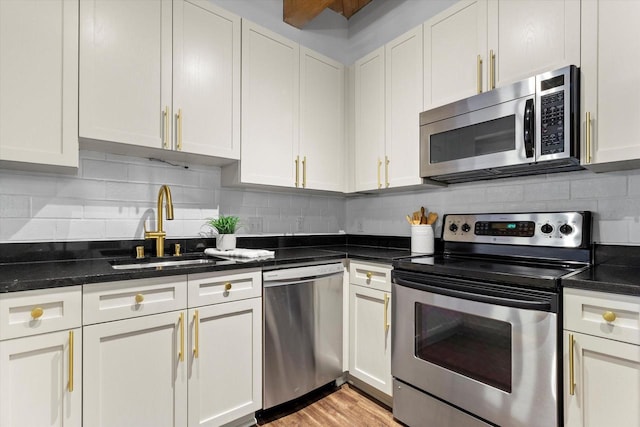 234 E Reservoir Ave Unit 104, Milwaukee, WI 53212 - kitchen featuring appliances with stainless steel finishes, a sink, backsplash, and white cabinets