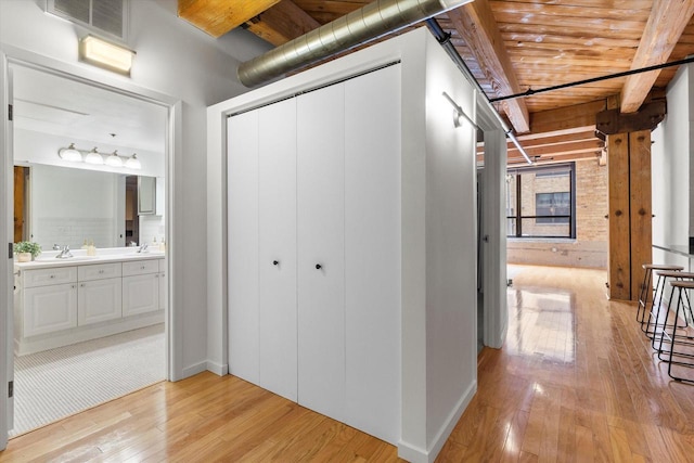 234 E Reservoir Ave Unit 104, Milwaukee, WI 53212 - corridor featuring light wood finished floors, a sink, beamed ceiling, wooden ceiling, and baseboards