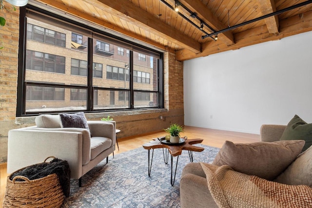 234 E Reservoir Ave Unit 104, Milwaukee, WI 53212 - sitting room featuring wooden ceiling, wood finished floors, beamed ceiling, brick wall, and track lighting