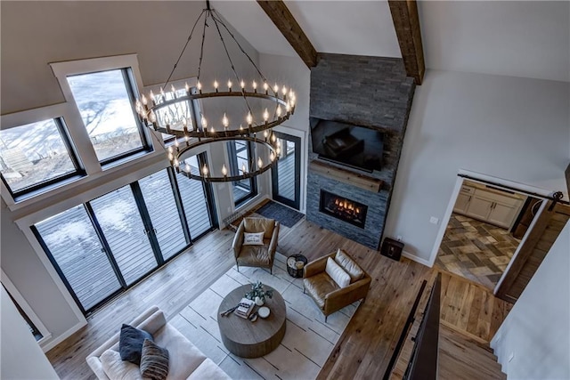 2936 W Sunset Bay, Birchwood, WI 54817 - living area with a chandelier, a high ceiling, wood finished floors, a stone fireplace, and beamed ceiling