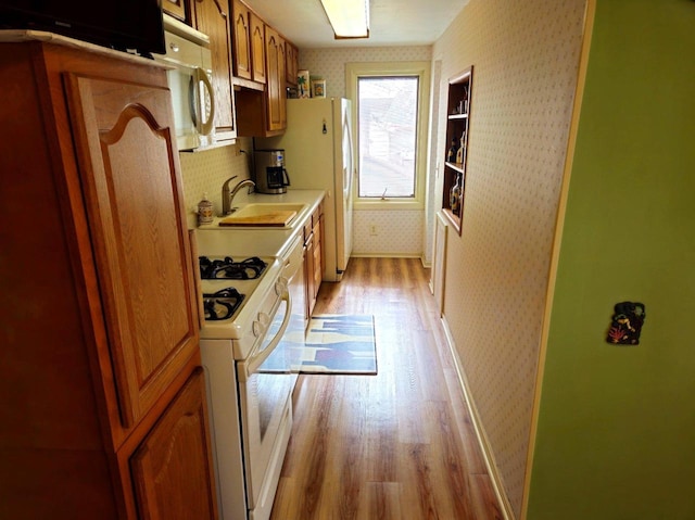 5449 Old Middleton Rd, Madison, WI 53705 - kitchen featuring wallpapered walls, white appliances, light wood finished floors, a sink, and light countertops