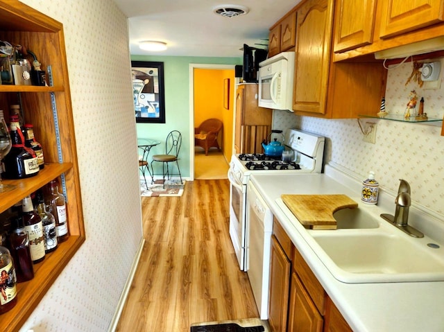 5449 Old Middleton Rd, Madison, WI 53705 - kitchen with white appliances, a sink, light wood-style floors, brown cabinetry, and light countertops