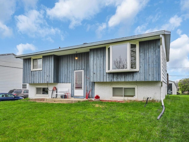 4715 Westway Ave, Racine, WI 53406 - rear view of house with a lawn, brick siding, and board and batten siding
