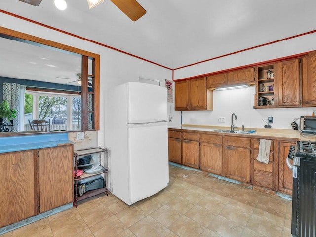 4715 Westway Ave, Racine, WI 53406 - kitchen featuring ceiling fan, freestanding refrigerator, a sink, stainless steel gas stove, and brown cabinetry