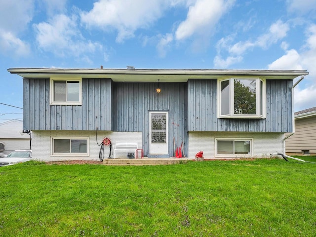 4715 Westway Ave, Racine, WI 53406 - back of house featuring board and batten siding, a yard, and brick siding