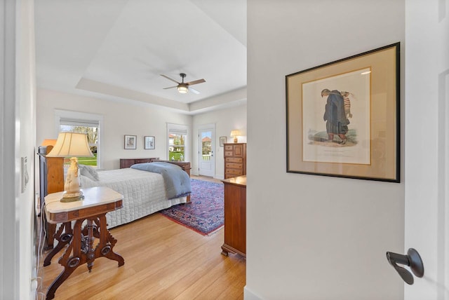 1387 Wilmington Way Unit 3-34, Lake Geneva, WI 53147 - bedroom with light wood-type flooring, a raised ceiling, and a ceiling fan