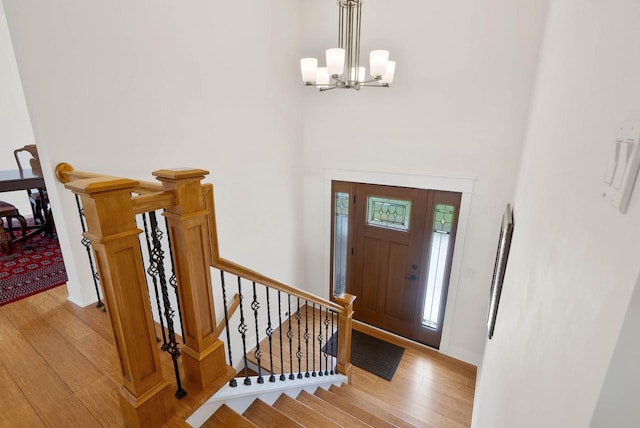 1387 Wilmington Way Unit 3-34, Lake Geneva, WI 53147 - entryway featuring light wood-style flooring, a chandelier, baseboards, and a towering ceiling