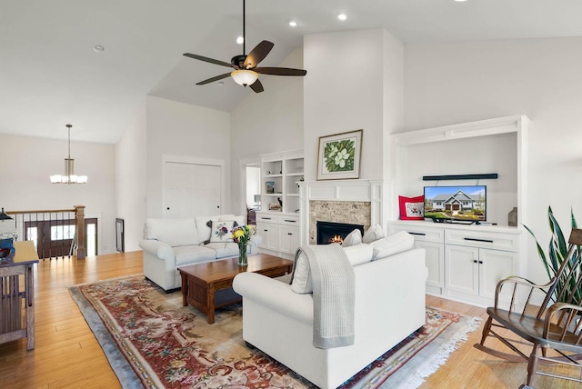 1387 Wilmington Way Unit 3-34, Lake Geneva, WI 53147 - living area with high vaulted ceiling, a ceiling fan, a tile fireplace, light wood-style floors, and a chandelier