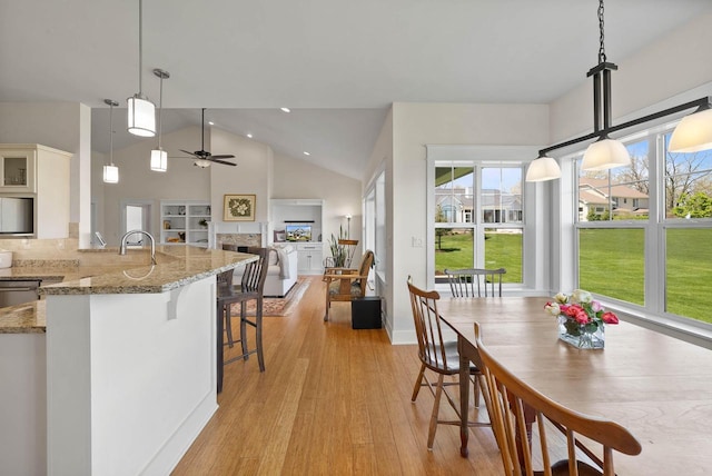 1387 Wilmington Way Unit 3-34, Lake Geneva, WI 53147 - dining area featuring a fireplace, light wood-style floors, ceiling fan, recessed lighting, and high vaulted ceiling